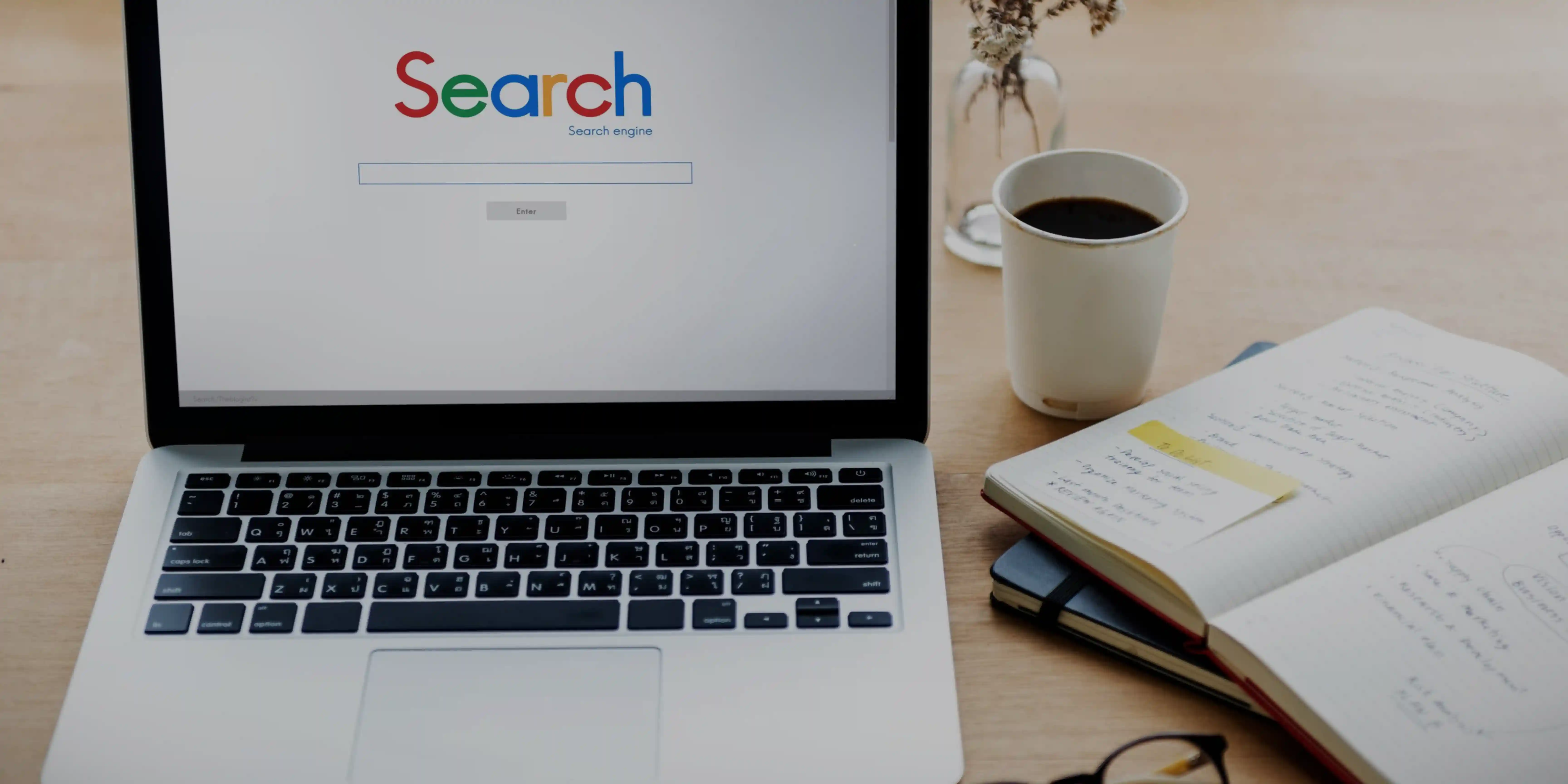 Essential SEO Tools for Online Success - Laptop, Scratch Book, and Stickers Symbolizing Our SEO Service.